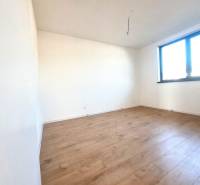 REZERVOVANÉ! Posledná novostavba 4-izbového dvojdomu v štandarde - Prázdna izba s podlahou s dreveným dekorom a veľkým oknom v rodinnom dome.