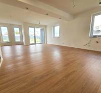 VEĽKORYSO RIEŠENÝ 4 izbový RD-128 m2 S TEP. ČERPADLOM, POZEMOK 405 m2 - Priestranná obývačka v rodinnom dome s podlahou s dreveným dekorom.