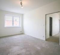 Kúpte si MODERNÚ NOVOSTAVBU 5i RD pri SENCI s MOŽNOSŤOU VÝMENY za BYT - Prázdna miestnosť s betónovou podlahou, oknom a otvorom do chodby v rodinnom dome.