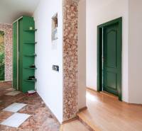 Kúpte si veľký PODKROVNÝ 4i BYT so ZÁHRADOU a PIVNICOU v Starom meste - Chodba v 4-izbovom byte s kamenným obkladom a zelenými dverami.