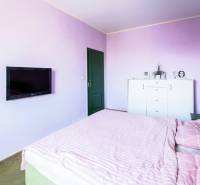 Kúpte si veľký PODKROVNÝ 4i BYT so ZÁHRADOU a PIVNICOU v Starom meste - Spálňa so svetloružovými stenami, posteľou a televízorom v 4-izbovom byte.