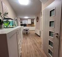 Dvojpodlažný 5i RD pri Dunajskej Strede, 55 min od BA - Interiér rodinného domu s kuchyňou, bielym nábytkom a podlahou s dreveným dekorom.