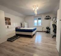 Dvojpodlažný 5i RD pri Dunajskej Strede, 55 min od BA - Spálňa v rodinnom dome s posteľou, bielym nábytkom a podlahou s dreveným dekorom.