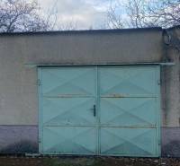  Na predaj  3i byt s vlastnou garážou neďaleko Šale - Garážová brána so svetlomodrými dverami a opadané listy v Seliciach.