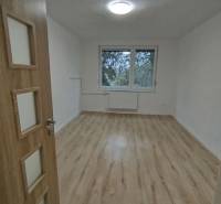  Na predaj  3i byt s vlastnou garážou neďaleko Šale - Priestranná izba v 3-izbovom byte s podlahou s dreveným dekorom a veľkým oknom.