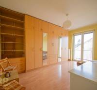 Rezervované: Na predaj pekný 2-izbový byt v centre mesta Poprad - Izba v 2-izbovom byte, s podlahou s dreveným dekorom a nábytkom v prírodných odtieňoch.