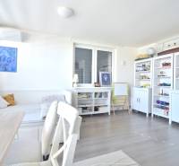 HROZNOVÁ, 4-i RD, 161 m2 – novostavba, krb, klíma, krásna záhrada - Svetlá izba v rodinnom dome s poličkami, stolom, sedačkou a dekoráciami na podlahe s dreveným dekorom.