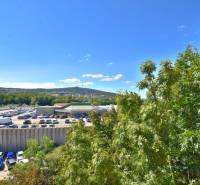 BAKOŠOVA, 1-i byt, 43 m2 – nerušený VÝHĽAD NA KARPATY - Parkovisko s autami a zeleňou pri Bakošovej ulici v Bratislave - Lamači.