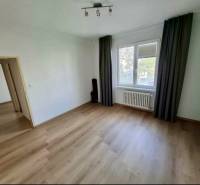 Prenájom 4 izbový byt, Čsl. Parašutistov, Bratislava III. Nové Mesto - Izba v 4-izbovom byte s podlahou s dreveným dekorom, závesmi, radiátorom.