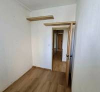 Prenájom 4 izbový byt, Čsl. Parašutistov, Bratislava III. Nové Mesto - Izba v 4-izbovom byte s podlahou s dreveným dekorom a poličkami na stene.