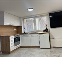 Dom za cenu bytu- komplet prerobený RD 3 izb. Blatné  - Kuchyňa v rodinnom dome s bielymi skrinkami a dekorom dreva.