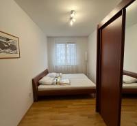 3i byt staršia novostavba, garáž, pivnica, Staré Mesto - Spálňa s posteľou, vstavanou skriňou a podlahou s dreveným dekorom v 3-izbovom byte.