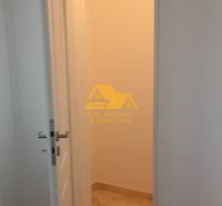 Prerobený 2 izbový byt s balkónom v Nových Zámkoch - Interiér 2-izbového bytu s otvorenými dverami a podlahou s dreveným dekorom.