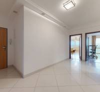 | Svetlý priestranný 2 izbový byt | parkovanie | REZERVOVANÝ - Vstupná chodba v 2-izbovom byte s bielymi stenami a keramickou dlažbou.