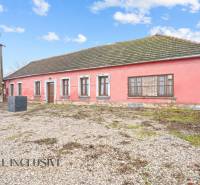 NA PREDAJ 4-IZBOVÝ RODINNÝ DOM V OBCI ŠINTAVA - Rodinný dom v Šintave s kamenným podkladom, ružovou fasádou a drevenými oknami.