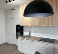 2 izbový byt na prenájom v centre Košíc  - Kuchyňa v 2-izbovom byte s podlahou s dreveným dekorom a svetlým nábytkom.