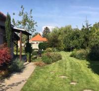 Dom s garážou na peknom rovinatom pozemku. - Záhrada pri rodinnom dome v Čiernej Vode s trávnikom a zeleňou.