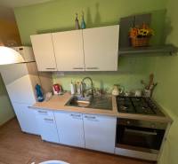 PREDAJ EXKLUZÍVNE: 1i byt s balk.; 41,02 m2; POPRAD; 124.200€ - Kuchyňa v 1-izbovom byte s bielymi skrinkami a podlahou s dreveným dekorom.