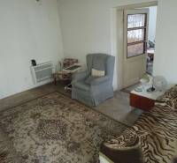 Predám Rodinný dom v Strekove - Izba v rodinnom dome s kobercom, kreslami a posteľou.