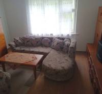 Predám Rodinný dom v Strekove - Obývacia izba v rodinnom dome s rohovou sedačkou a stolíkom na podlahe s dreveným dekorom.