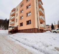 Luxusný dvojizbový byt v Oščadnici- TOP cena! - Bytový dom v zasneženej Oščadnici s 2-izbovým bytom, okolo ktorého je zimná krajina.