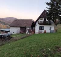 Samota Nová Baňa – Štále s hospodárskymi stavbami - Na obrázku je rodinný dom v prírodnom prostredí, na svahu s výhľadom na lesy.