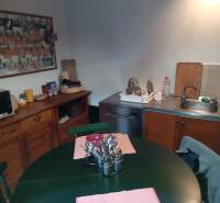 Samota Nová Baňa – Štále s hospodárskymi stavbami  - Kuchyňa v rodinnom dome s drevenou komodou, jedálenským stolom a umývadlom.