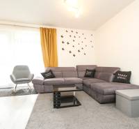 3i byt + záhradka 94m2 + parking, Vinohrady, Trenčín - Svetlá obývacia izba s rohovou sedačkou a nástennými dekoráciami v 3-izbovom byte.