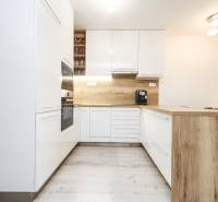 3i byt + záhradka 94m2 + parking, Vinohrady, Trenčín - Kuchyňa v 3-izbovom byte s bielymi skrinkami, dreveným obkladom a spotrebičmi.