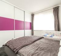 3i byt + záhradka 94m2 + parking, Vinohrady, Trenčín - Spálňa s posteľou, skriňou s farebnými dverami a detskou postieľkou v 3-izbovom byte.