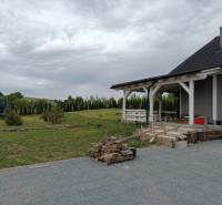 Rekreačná chata Nová Baňa - Drozdovo - Na obrázku je chata s priestrannou záhradou, trampolína a drevo na kúrenie.