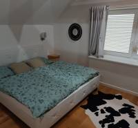 Rekreačná chata Nová Baňa - Drozdovo - Spálňa s posteľou a koberec v chate, drevená podlaha, príjemné osvetlenie miestnosti.