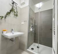 Súčasný 2-izbový byt v novostavbe – Matadorka  - Kúpeľňa v dvojgarsónke s jednoduchým umývadlom a sprchovým kútom so sklenenými dverami.