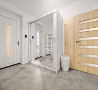 MODERNÝ 5-IZBOVÝ RODINNÝ DOM V ČUNOVE: 180m2 KOMFORTU A TICHA - Vstupná hala s podlahou s dreveným dekorom, zrkadlová skriňa a svetlé dvere v rodinnom dome.