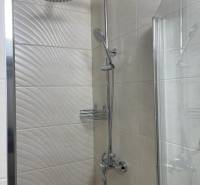 REZERVOVANÉ! Nadštandardný 1-izbový byt, ul. 1. mája, Vráble - Sprchový kút v 1-izbovom byte, obloženie s textúrou a sklenenou stenou.