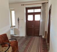 Všetko po čom túžite - dom, relax, kúpele, kúpalisko - Chodba rodinného domu s kachličkovou podlahou, kreslom a závesom.