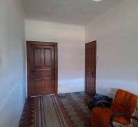 Všetko po čom túžite - dom, relax, kúpele, kúpalisko - Interiér rodinného domu s dverami, kreslom a kobercovým chodníkom.