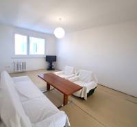 Na Predaj  4-izb. byt, Hornádska 28, Bratislava. - Obývačka so stolom a pohovkou v 4-izbovom byte, podlaha s dreveným dekorom.