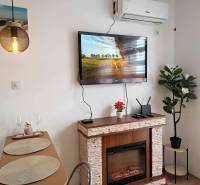 Predaj, štúdio 27 m2, rezort Sunny day, Slnečné pobrežie, Bulharsko - Interiér rekreačného apartmánu s krbom, televízorom a jedálenským stolom.