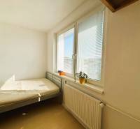 Slnečný dvojizbový byt – 43,5 m² v Bratislave – Vajnory - Svetlá spálňa s posteľou, oknom, žalúziami a podlahou s dreveným dekorom v 2-izbovom byte.