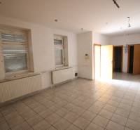 Ponúka na predaj budovu - centrum Senca - NOVÁ SUPER CENA  - Prázdna miestnosť s radiátormi, oknami, dlažbou; priestor na ulici Mierové nám. a budova.