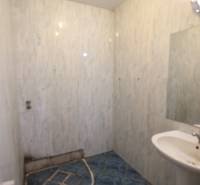 Ponúka na predaj budovu - centrum Senca - NOVÁ SUPER CENA  - Kúpeľňa s modrou dlažbou, umývadlom a jednoduchým osvetlením; na ulici Mierové nám.