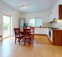 Svetlý 2i byt + 200 m² záhrada | Biely Kostol - Kuchyňa v 2-izbovom byte s podlahou s dreveným dekorom a jedálenským stolom.