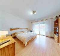 Svetlý 2i byt + 200 m² záhrada | Biely Kostol - Svetlá spálňa v 2-izbovom byte s posteľou a podlahou s dreveným dekorom.