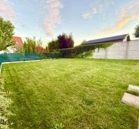 Svetlý 2i byt + 200 m² záhrada | Biely Kostol - Záhrada s trávnikom, stromami a plotom v Bielom Kostole pri dvojizbovom byte.