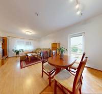 Svetlý 2i byt + 200 m² záhrada | Biely Kostol - Obývačka v 2-izbovom byte s dreveným dekorom podlahy, jedálenským stolom a sedacou súpravou.