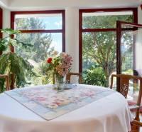 Bývanie ako v raji pri lagúne | Šamorín - Jedáleň vo vile s kvetinovým aranžmánom na stole a veľkými oknami.