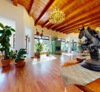 Bývanie ako v raji pri lagúne | Šamorín - Interiér vily s podlahou s dreveným dekorom, sochou jazdca a izbovými rastlinami.