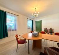 Bývanie ako v raji pri lagúne | Šamorín - Jedáleň vo vile s podlahou s dreveným dekorom, zelenými dverami a tmavozelenými závesmi.