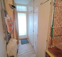 Na predaj veľkometrážny 3 izbový byt Žarnovica - Úzka chodba s podlahou s dreveným dekorom, skriňami a dverami v 3-izbovom byte.